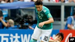 L'Allemand Mesut Ozil et le Sud-Coréen Koo Ja-cheol lors du match de la Coupe du monde de football à Kazan, Russie, le 27 juin 2018.