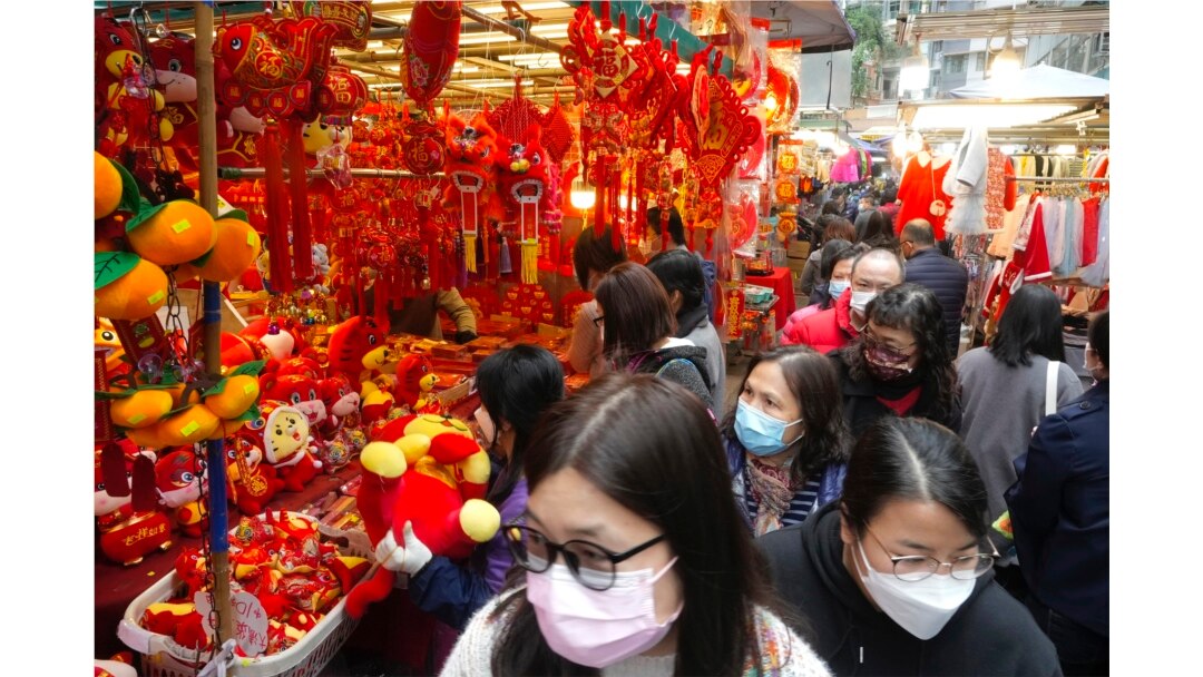 Orang-orang berjalan melewati dekorasi Tahun Baru Imlek di pasar untuk merayakan Tahun Baru Imlek di Hong Kong, Senin, 31 Januari 2022. Tahun Baru Imlek jatuh pada 1 Februari (Foto: AP/Vincent Yu)