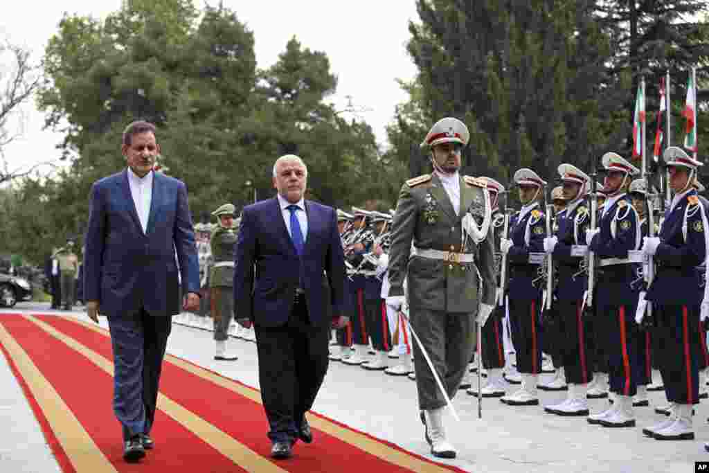 Iranian Vice President Eshagh Jahangiri (left) walks with Iraqi Prime Minister Heidar al-Abadi (center) during a welcoming ceremony at Saadabad Palace, Tehran, Iran, Oct. 21, 2014. 
