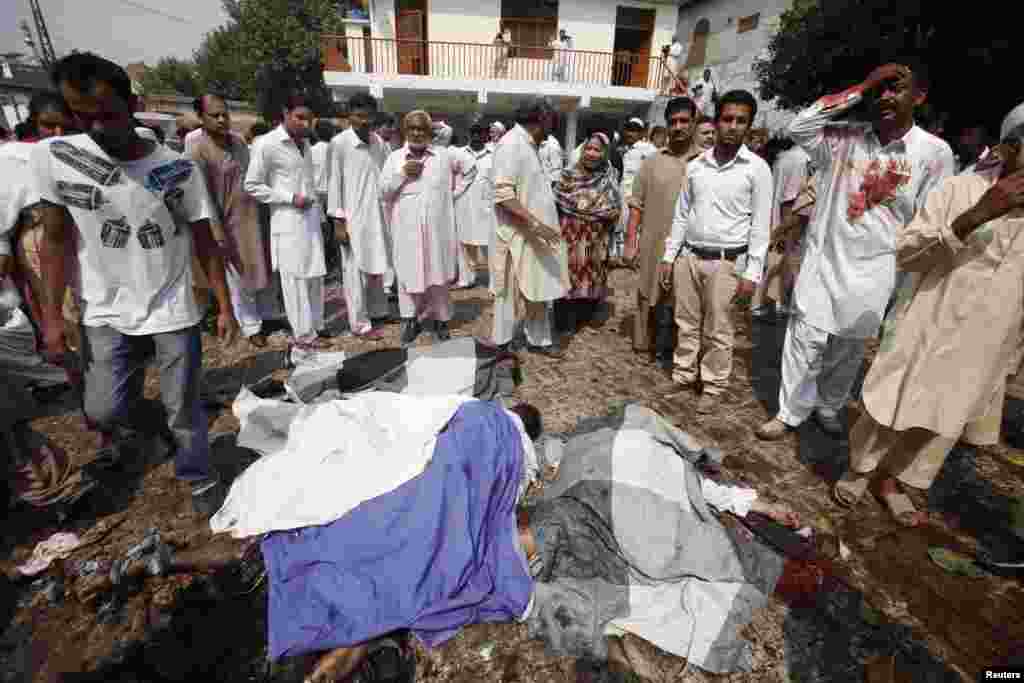 People gather around dead bodies at the site of a suicide blast at a church in Peshawar, Pakistan, Sept. 22, 2013. 