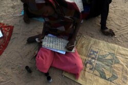 Seorang gadis menulis ayat-ayat Quran saat belajar mengaji di bulan Ramadan, di Khalwa Syekh Tigani di wilayah Tulus, selatan Darfur, Sudan, 6 Juni 2017. (REUTERS/Mohamed Nureldin Abdallah)