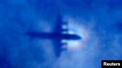 La silueta de un avión P3 Orion de la Fuerza Aérea Neozelandesa cruza nubes bajas durante la búsqueda del vuelo 370 de Malaysian Airlines.