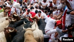 Những người tham dự cố chạy thoát bò húc tại lễ hội San Fermin ở Pamplona, 13/7/2013