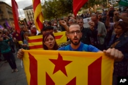 Pro-independence supporters hold up "esteleda" or pro-independence flags and shout slogans as they walk along the street during a demonstration in Pamplona, Spain, Oct. 3, 2017, protesting against the use of force by police.