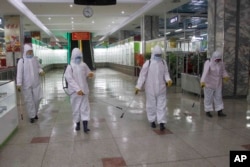 Staf Pyongyang Department Store mendisinfeksi toko di Pyongyang, Korea Utara, 28 Desember 2020. (Foto: AP)