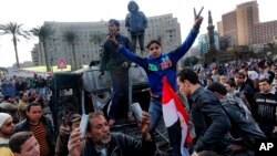 Egyptian protesters celebrate the capture of a state security armored vehicle that demonstrators commandeered during clashes with security forces and brought to Tahrir Square in Cairo, January 29, 2013. 
