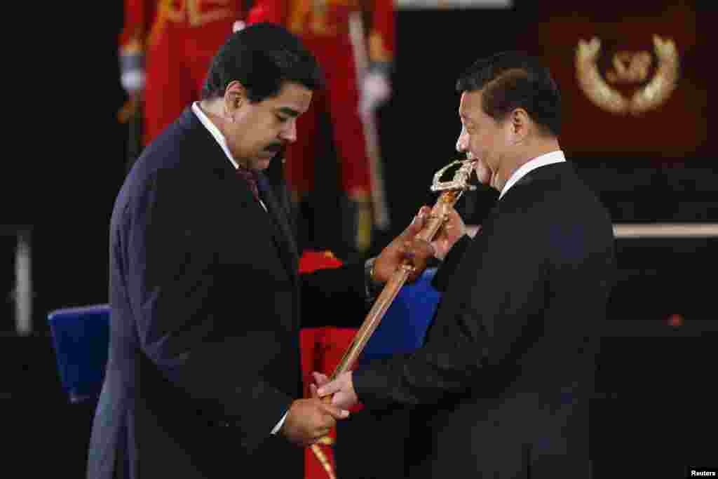 Venezuelan President Nicolas Maduro, left,&nbsp; presents Chinese President Xi Jinping with a replica of the sword of national hero Simon Bolivar during a ceremony at the National Pantheon in Caracas, July 20, 2014.