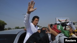 Politisi Imran Khan (tengah) melambai kepada para pendukungnya saat memimpin protes anti serangan misil AS di Pakistan (7/10). 