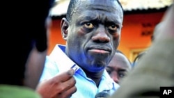 Ugandan opposition leader Kizza Besigye speaks to journalists in the yard outside his house upon returning home after a confrontation with police, in Kasangati, Uganda, May 19, 2011