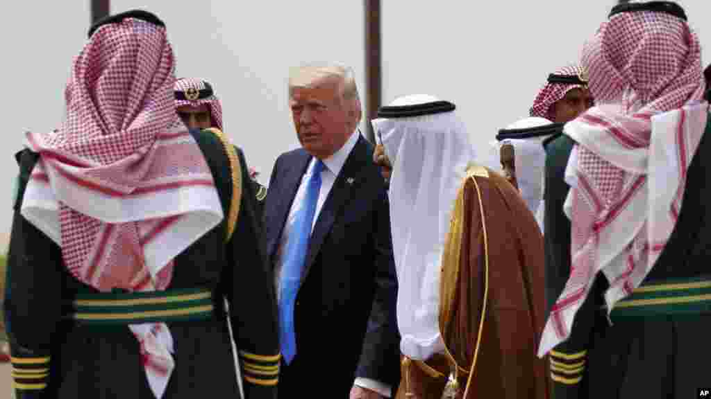 Le président Donald Trump, au centre, à gauche, marche aux côtés du roi saoudien Salman à l&rsquo;aéroport international roi Khalid, Ryad 20 mai 2017.