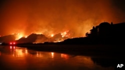 FILE - A wildfire burns along the 101 freeway in Ventura, Calif., Dec. 5, 2017. State fire officials said Friday that the Thomas fire has scorched 273,400 acres, or about 427 square miles of coastal foothills and national forest. 