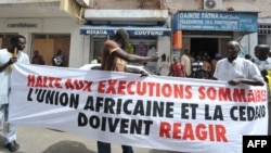 Protesters gather outside the Gambian Embassy in Senegal on August 30, 2012. The banner reads: " Stop summary executions. The African Union and ECOWAS must react." 