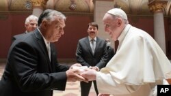 Pope Francis exchanges gifts with Hungarian Prime Minister Viktor Orban, at Budapest's Museum of Fine Arts, Sept. 12, 2021. 