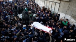 Mourners and Palestinian Hamas members carry the body of their comrade, who was killed in an Israeli airstrike, during his funeral in Gaza City, Dec. 9, 2017.