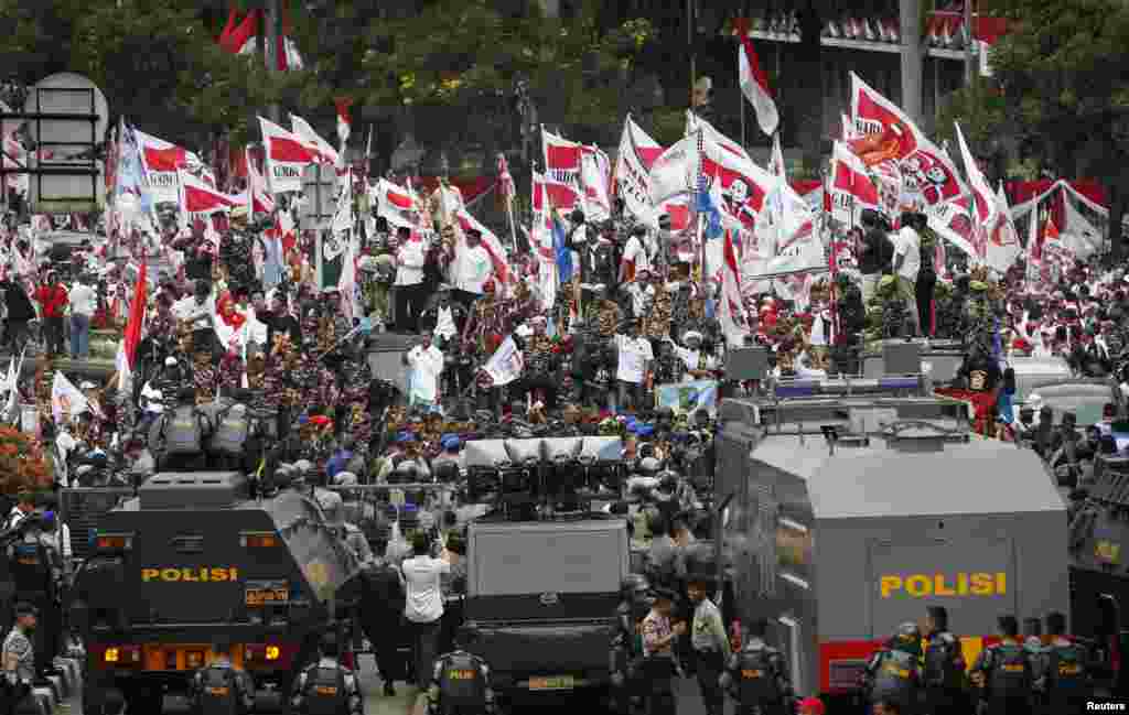 Para pendukung kandidat presiden yang kalah, Prabowo Subianto, berunjuk rasa di depan barisan polisi di luar Mahkamah Konstitusi di Jakarta (21/8).&nbsp;(Reuters/Darren Whiteside)