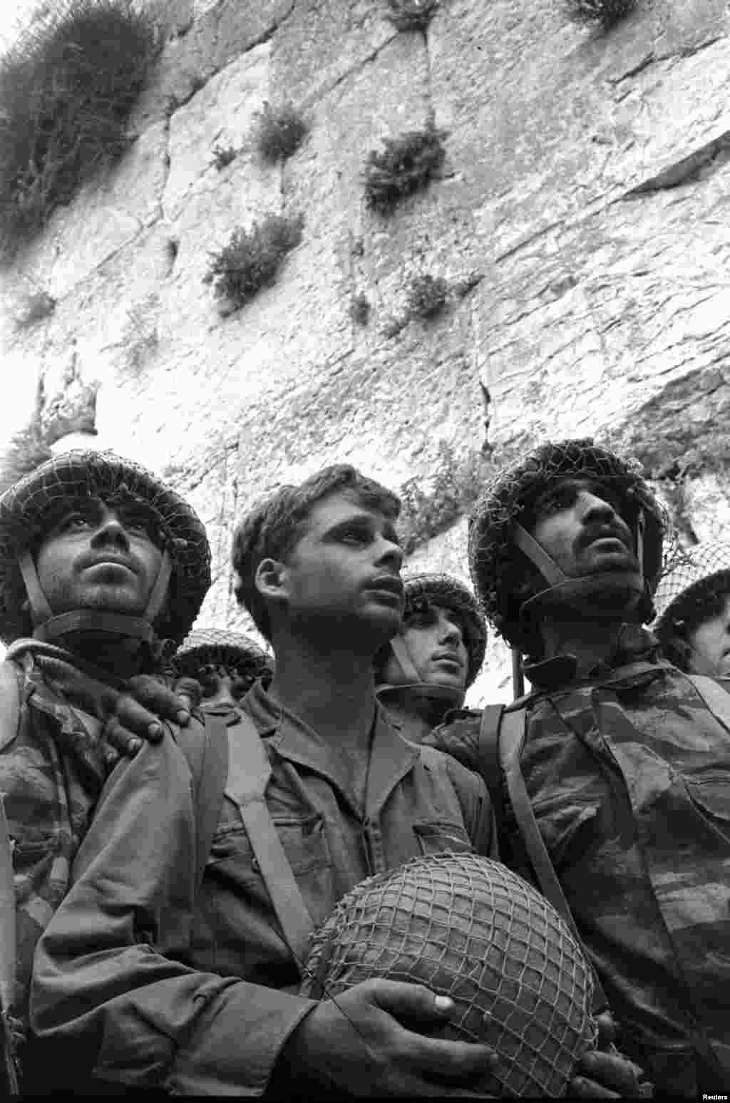 Isroillik askarlar Quddusning Eski shahar qismiga kirib borayapti / Israeli paratroopers stand in front of the Western wall in Jerusalem&#39;s Old City in June 1967 after it was captured during the Middle East War.