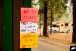 A sign warns departing campers of closures, July 25, 2018, in Yosemite National Park, Calif. Parts of the park closed Wednesday as firefighters work to contain the Ferguson Fire.