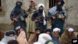 FILE - In this Nov. 3, 2015 file photo, Afghan Taliban fighters listen to Mullah Mohammed Rasool, the newly-elected leader of a breakaway faction of the Taliban, in Farah province, Afghanistan.