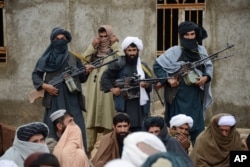 FILE - In this Nov. 3, 2015 file photo, Afghan Taliban fighters listen to Mullah Mohammed Rasool, the newly-elected leader of a breakaway faction of the Taliban, in Farah province, Afghanistan.