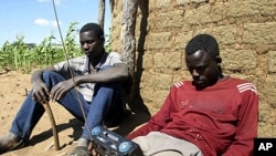 Zimbabweans listen to a radio for an announcement of election results in Umguza April 1, 2008 (file photo).