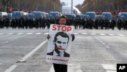 Một người biểu tình cầm ảnh chân dung của ông Macron hôm 8/12.