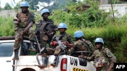 Des Casques-bleus de la mission de stabilisation des Nations unies en République démocratique du Congo sont assis à l'arrière d'une camionnette à Beni, Nord-Kivu, RDC, 23 octobre 2014.