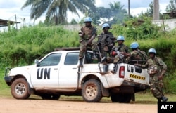 FILE - Blue-helmeted members of the U.N. Organization Stabilization Mission in the Democratic Republic of Congo sit on the back of a pickup truck in Beni, Oct. 23, 2014.