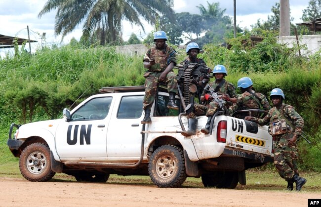 FILE - Blue-helmeted members of the U.N. Organization Stabilization Mission in the Democratic Republic of Congo sit on the back of a pickup truck in Beni, Oct. 23, 2014.