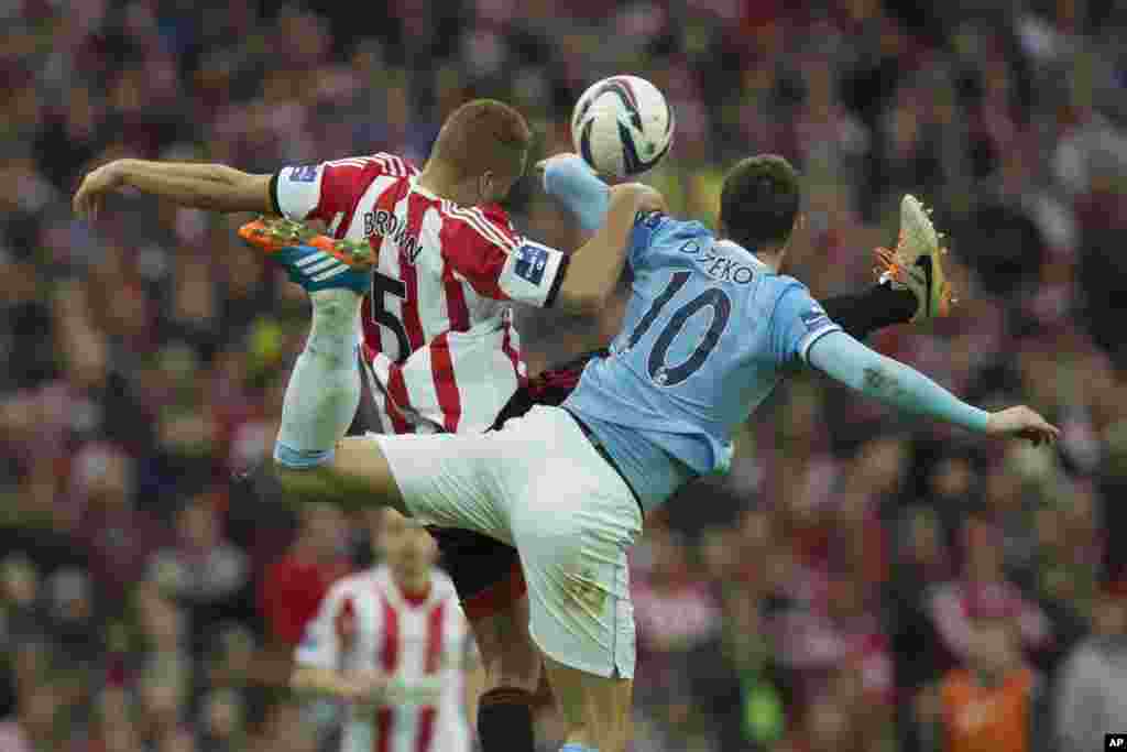 Edin Dzeko na Manchester City, a dama, yana kokawar neman kwallo da Wes Brown na Sunderland a wasan karshe na cin kofin Lig na Ingila da aka buga a filin wasa na Wembley dake London, Lahadi, 2 Maris, 2014. 