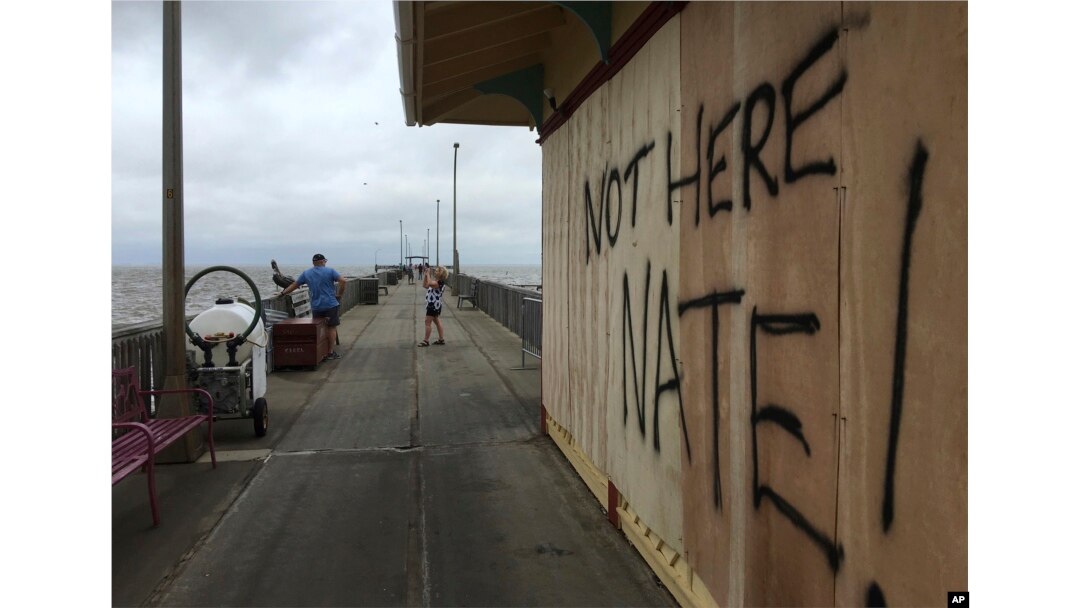 People shoot photos near a sign on the Shux on the Pier restaurant in Fairhope, Alabama, Oct. 8, 2017.