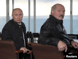 FILE - Russia's President Vladimir Putin, left, and Belarus' President Alexander Lukashenko watch the joint war games Zapad-2013 (West-2013) at Khmelevka base in the Kaliningrad Region, Sept. 26, 2013.