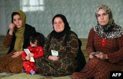 Women and young girls listen to Kurdistan Rasul (not pictured), an Iraqi Kurdish activist with the nonprofit organization WADI, as she speaks about the harms of genital mutilation in Sharboty Saghira, Iraq, Dec. 3, 2018. Female genital mutilation appears to have been practiced for decades in Iraq's Kurdish region, usually known for more progressive stances on women's rights.