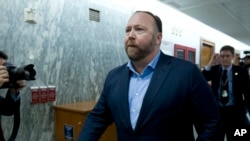 FILE - Alex Jones, the right-wing conspiracy theorist, walks the corridors of Capitol Hill after listening to testimony on Capitol Hill in Washington, Sept. 5, 2018.