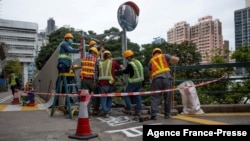 2022年1月29日，香港建筑工人用铁板覆盖住漆有六四标语的港大太古桥桥面。