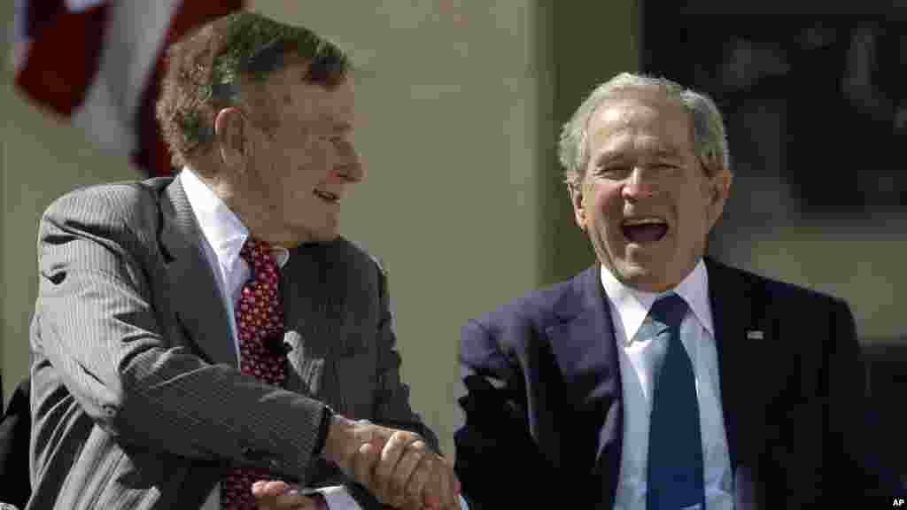 L&#39;ancien président George H. W. Bush serre la main de son fils, l&#39;ancien président George W. Bush lors de l&#39;inauguration du Centre George W. Bush présidentielle, Dallas, le jeudi 25 Avril 2013.