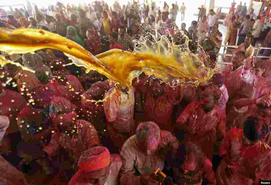 Hindu devotees daubed in colors sing religious songs inside a temple during Holi celebrations in Ahmedabad, India.