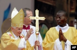 Pope Benedict XVI waves to the Catholic faithful as he departs following Sunday Mass, at the national stadium in Cotonou, Benin, Nov. 20, 2011.