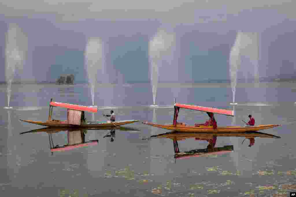 Kashmiri boatmen row their Shikara on Dal Lake in the outskirts of Srinagar, India.