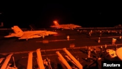 Chiến đấu cơ F/A-18 Super Hornet chuẩn bị cất cánh từ boong tàu bay của tàu sân bay USS George HW Bush (CVN 77) để thực hiện nhiệm vụ tấn công các mục tiêu IS ở Syria.