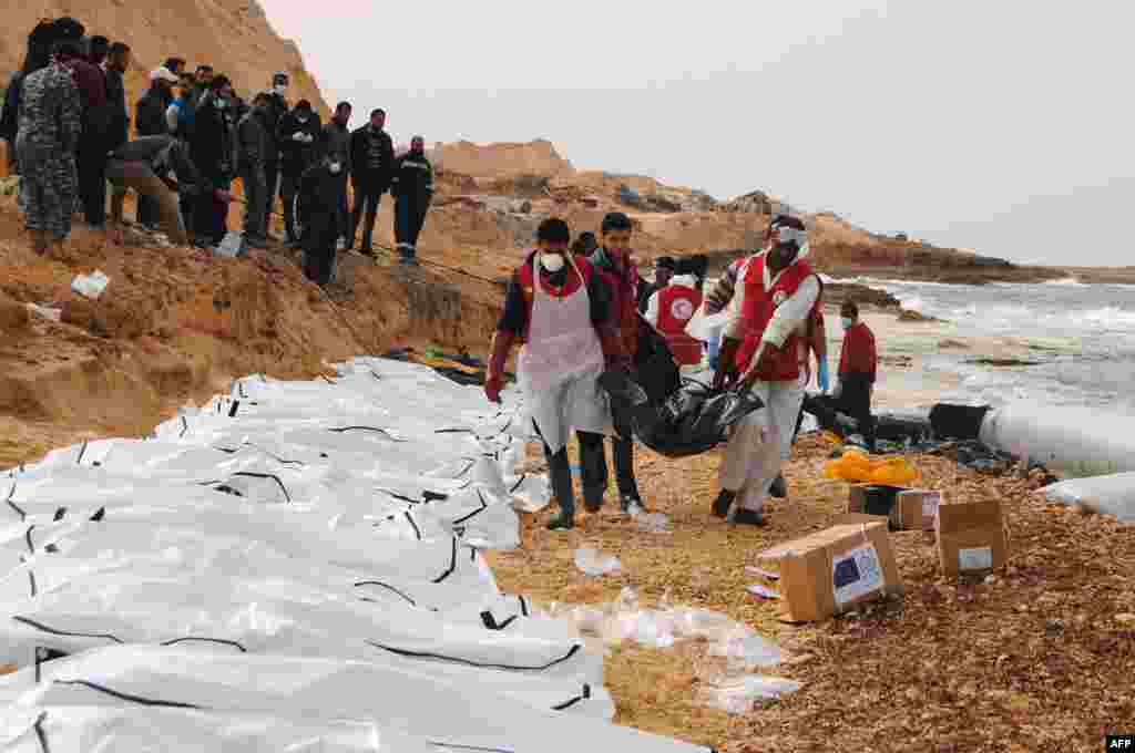 지난 20일(현지시간) 리비아 적신월사(이슬람권의 적십자사에 해당) 자원봉사자들이 북부 해안에 떠밀려온 난민 시신 74구를 수습하고 있다. 적신월사 측은 전날 파손된 고무보트가 인근에서 발견됐다고 밝히고,120명까지 탑승이 가능한 보트 외형을 볼 때 시신이 추가 발견될 것으로 예상했다. &nbsp;