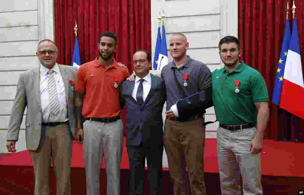 From the left, British businessman Chris Norman, Anthony Sadler, a senior at California State University, Sacramento, French President Francois Hollande, U.S. Airman Spencer Stone, and Alek Skarlatos, a U.S. National Guardsman from Roseburg, Oregon pose at the Elysee Palace, in Paris, France, Aug. 24, 2015.