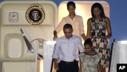 Presiden Barack Obama dan keluarga saat tiba di Honolulu untuk memulai liburan mereka (22/12). (AP/Gerald Herbert)
