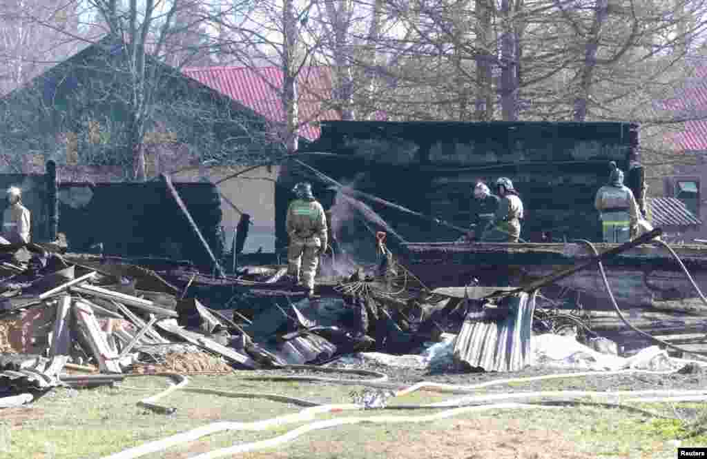 Russian emergency service staff work at the site of a fire at a psychiatric hospital in the village of Ramensky, north of Moscow, April 26, 2013.