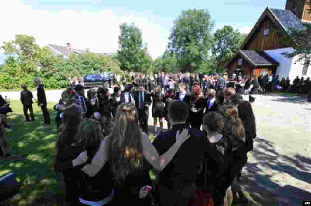 Mourners gather in a circle to console themselves prior to the funeral procession of Bano Abobakar Rashid, 18, the first victim of the shooting rampage at Utoeya to be buried, during her funeral at a church in Nesodden, near Oslo, Norway, Friday July 29,