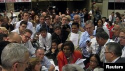 Ministers gather in a huddle where agreement was reached to extend the Kyoto Protocol during a plenary session at the United Nations Climate Change Conference (COP17) in Durban, December 11, 2011.