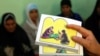 FILE - A counselor holds up cards used to educate women about female genital mutilation (FGM) in Minia, June 13, 2006. 