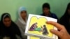 FILE - A counselor holds up cards used to educate women about female genital mutilation (FGM) in Minia, Egypt, June 13, 2006. 