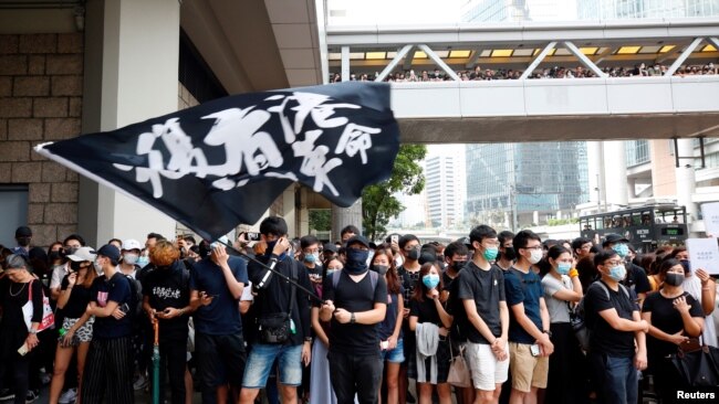 Supporters of jailed activist Edward Leung, gather outside the High Court as Leung appeals against a conviction and sentence, in Hong Kong, China Oct. 9, 2019. Text on flag reads,