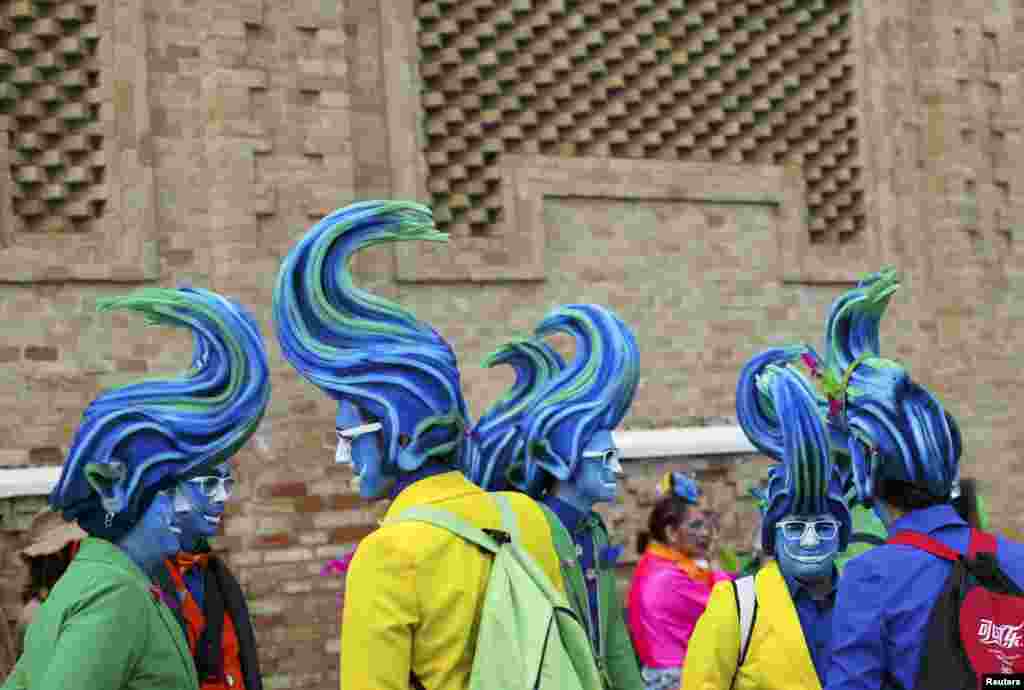 Men in fancy costumes chat during the Carnival of Cadiz in southern Spain.