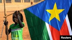 A girl holds a South Sudan flag on January 30 during the announcement of the preliminary results of voting on independence.